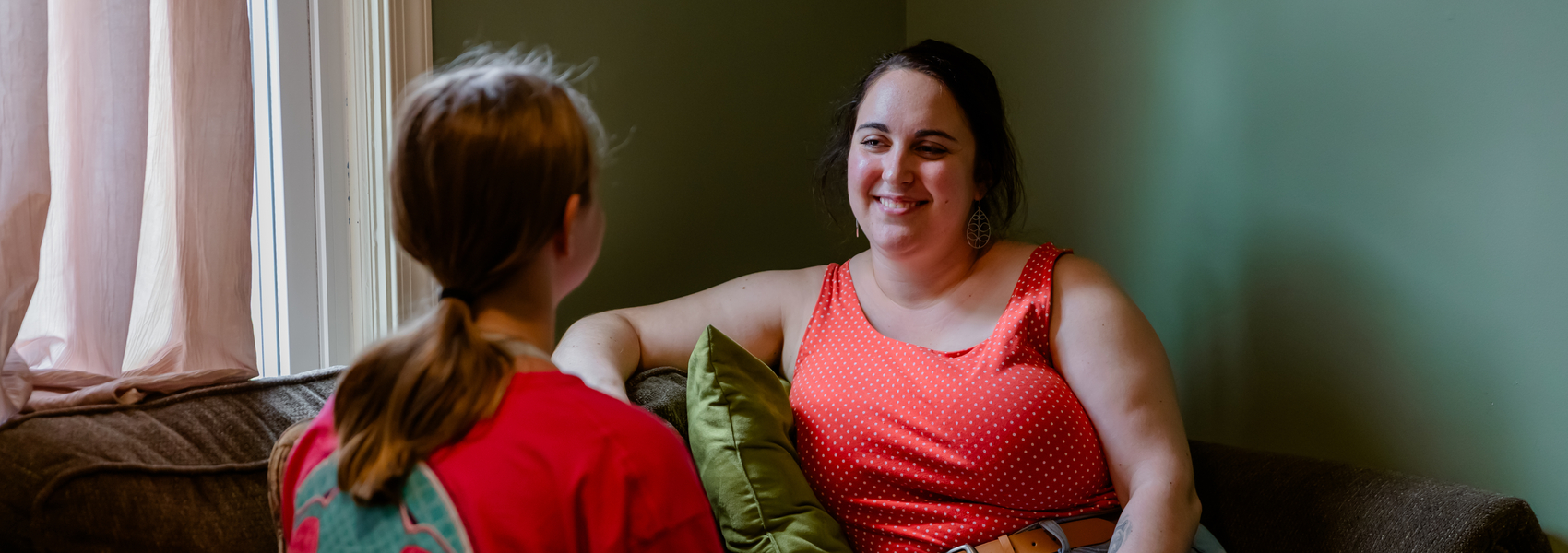 A young foster mom talks to a teen girl at home